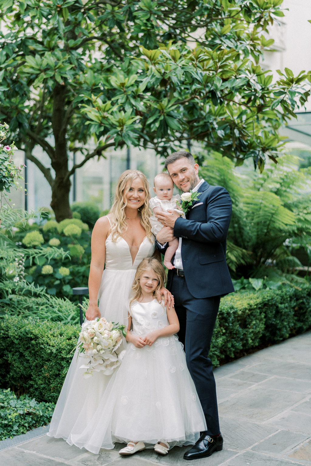 Bride groom little girl and baby girl in garden