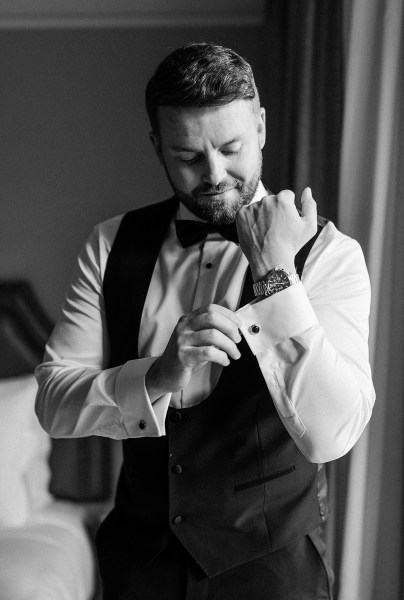 Black and white groom getting ready in room