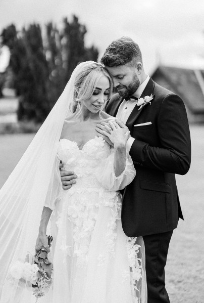 Black and white of bride and groom hands touching each other shoulder arm around waist