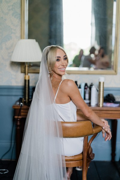 Image of bride as she's getting ready veil detail