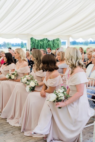 Shot of bridesmaids seated holding bouquet of flowers