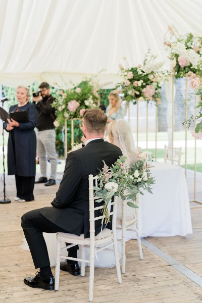 Bride and groom sitting at alter in front of celebrant