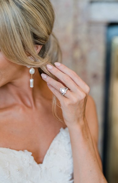 Brides hand showing ring and earring/hair detail