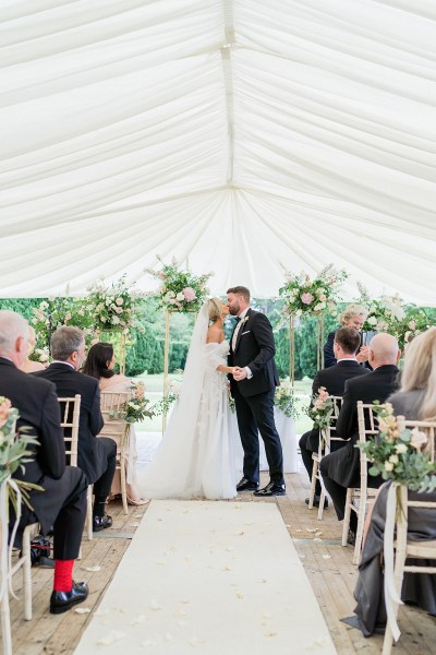 Confetti thrown on couple bride and groom exit ceremonial room guests clap the couple kiss