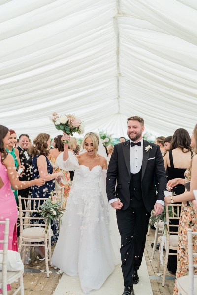 Confetti thrown on couple bride and groom exit ceremonial room guests clap