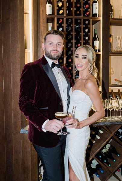 Groom enjoys espresso martini and bride enjoys cocktail in glass