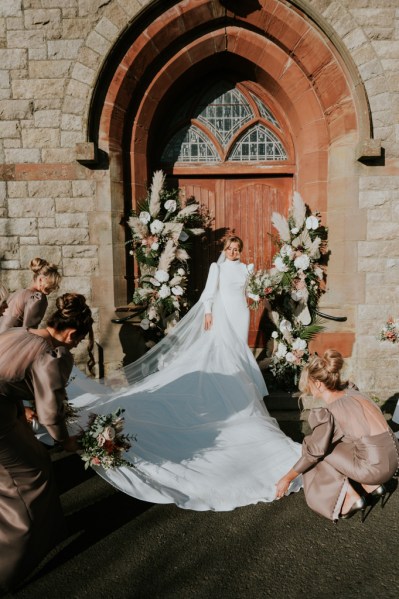 Bride outside church with bridesmaids getting ready