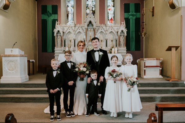 Groom bride children daughters and sons in church at alter