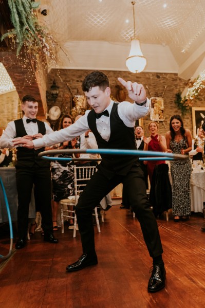 Groom using limbo spinning on dancefloor