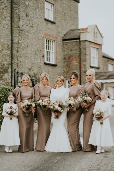 Bride in the middle of bridesmaids and children wearing white