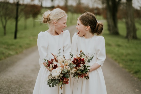 Two little girls smirk and smile at each other