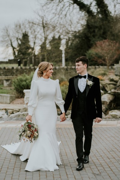 Bride and groom holding hands walking hand in hand looking at each other