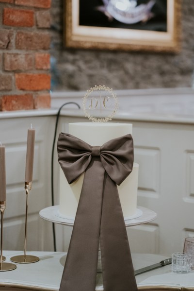 Brown bow on top of wedding cake