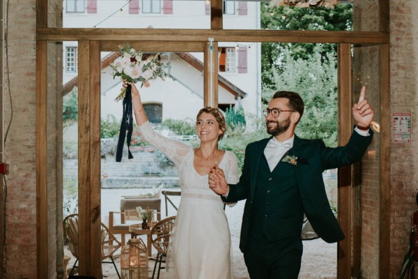 Bride and groom enter ballroom bouquet in the air