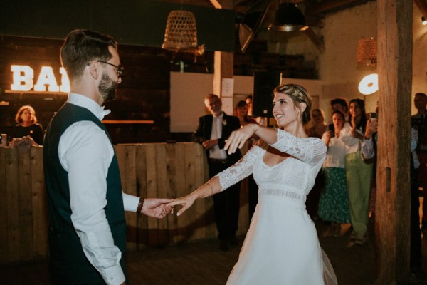 Bride and groom embrace on the dancefloor dance and smile