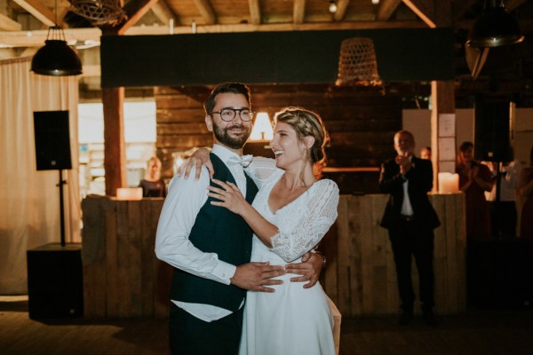 Bride and groom embrace on the dancefloor dance and smile