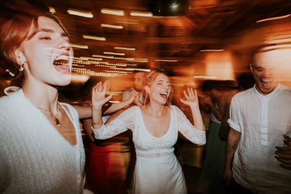 Bride laughing dancing with guests on the dancefloor