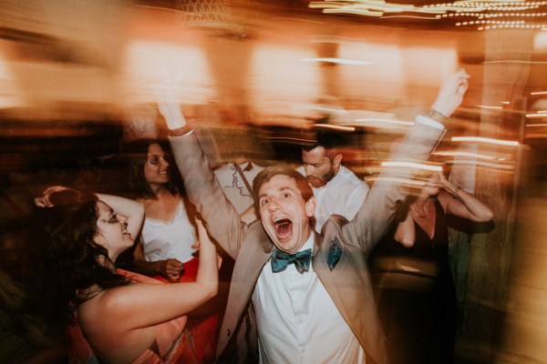 Screaming joyous guest with his hands up in the air