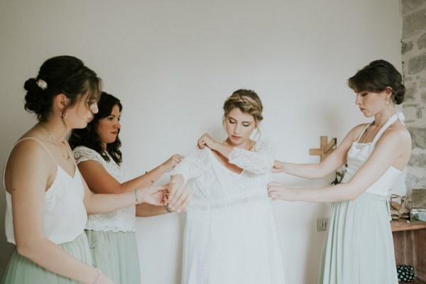 Bride gets help from her bridesmaids as they get ready