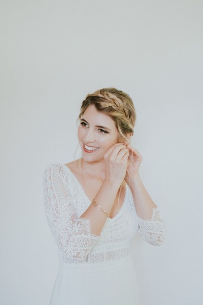 Bride putting on her earrings getting ready