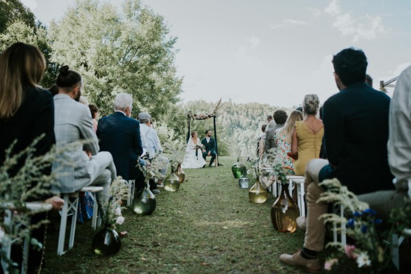 View of bride and groom at alter in front of guests