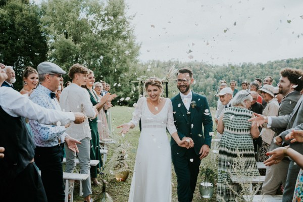 Bride and groom confetti being thrown over couple and guests