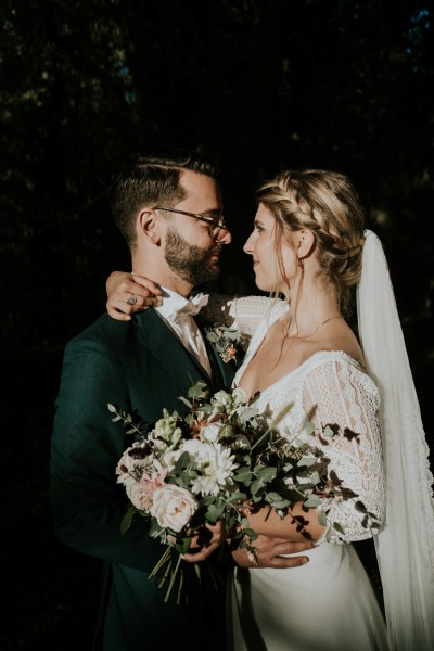 Dark photography of couple smiling bride and groom embrace