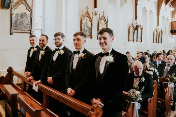 Groomsman standing in church pew