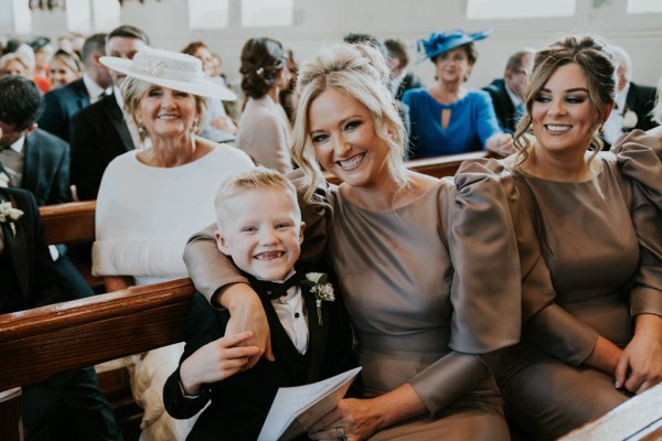 Woman bridesmaids and little boy pose for a photo