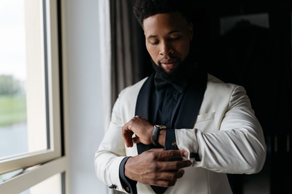 Groom gets ready beside window watch and shirt detail