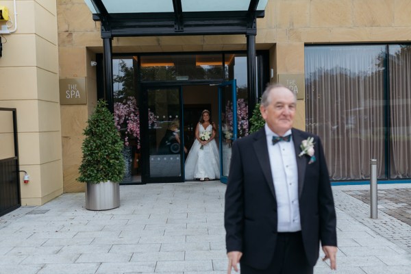 Father of the bride awaits his daughter she is behind him