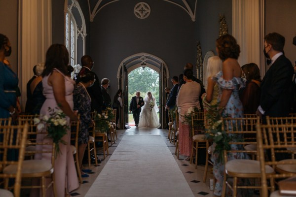 Father of the bride is about to walk his daughter down the aisle in dhurch