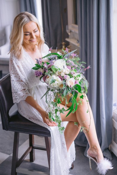 Bride holding roses bouquet of flowers on her lap