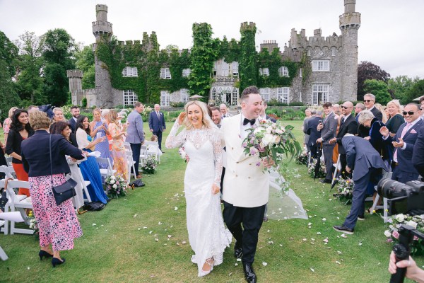 Bride and groom exit the ceremony pronounced husband and wife confetti guests clapping