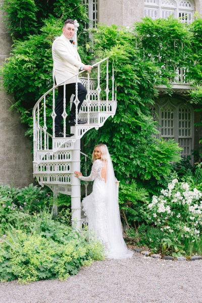 Bride follows groom up the white staircase