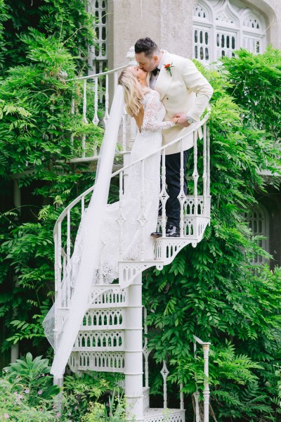 Bride and groom walk up the staircase leading to the castle garden surrounds