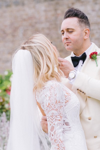 Groom touches brides face