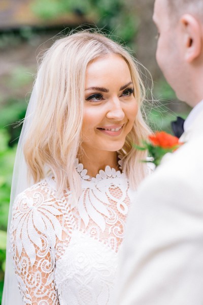 Bride looks at groom smiling in awe