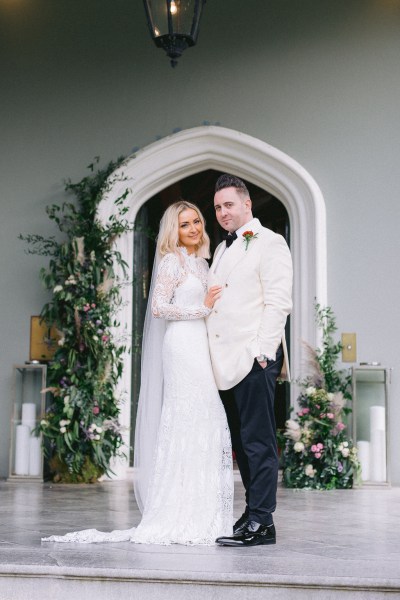 Bride and groom pose outside of venue