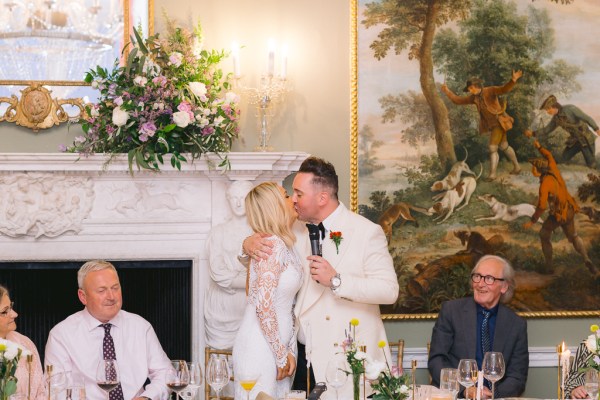 Bride and groom kiss at the wedding table