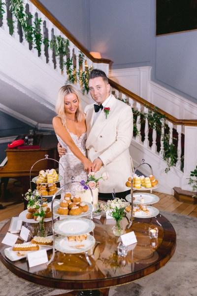 Bride and groom cut the wedding cake together