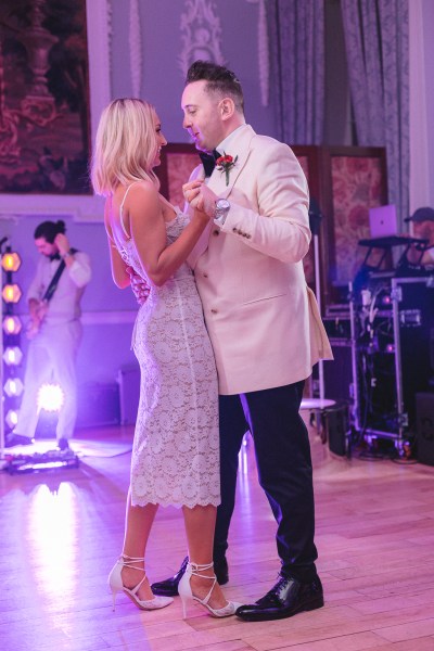 Pink hue picture of bride and groom dancing on the dancefloor