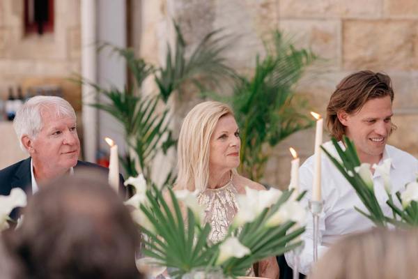 Blonde woman sitting at table men on either side of her