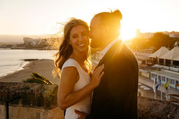 Sunset behind grooms head bride smiles