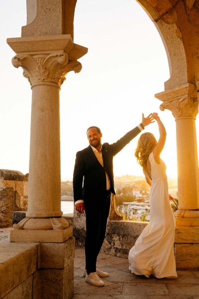 Groom dances with his bride on the balcony pillars in view