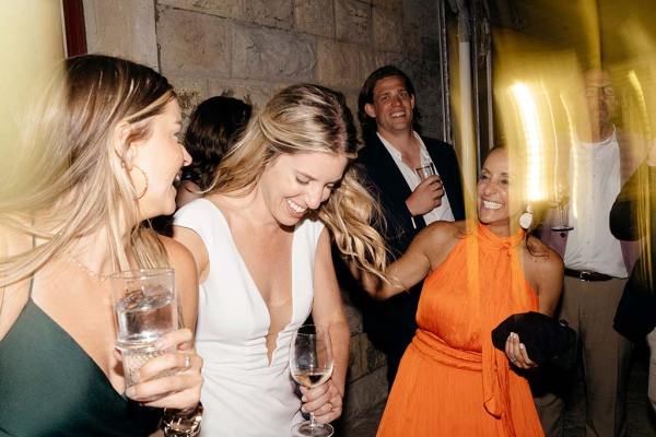 Woman wearing orange dress and bride dance on the dancefloor