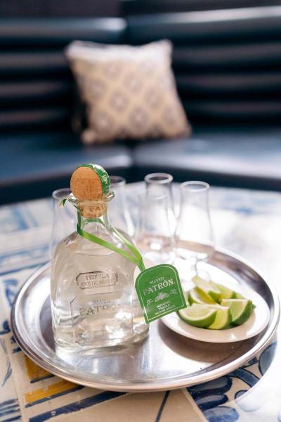 Groom holds up bottle of gin beverages alcohol lime and glasses