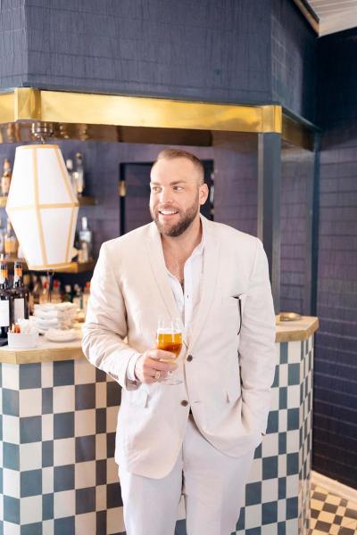 Groomsman or man is drinking a cocktail beverage beside bar