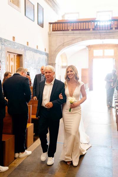 Father of the bride walks her down the aisle in cathedral