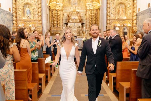 Bride and groom exit the cathedral guests behind them clapping